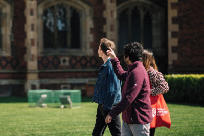 A group of students walk around the quad at Queen's